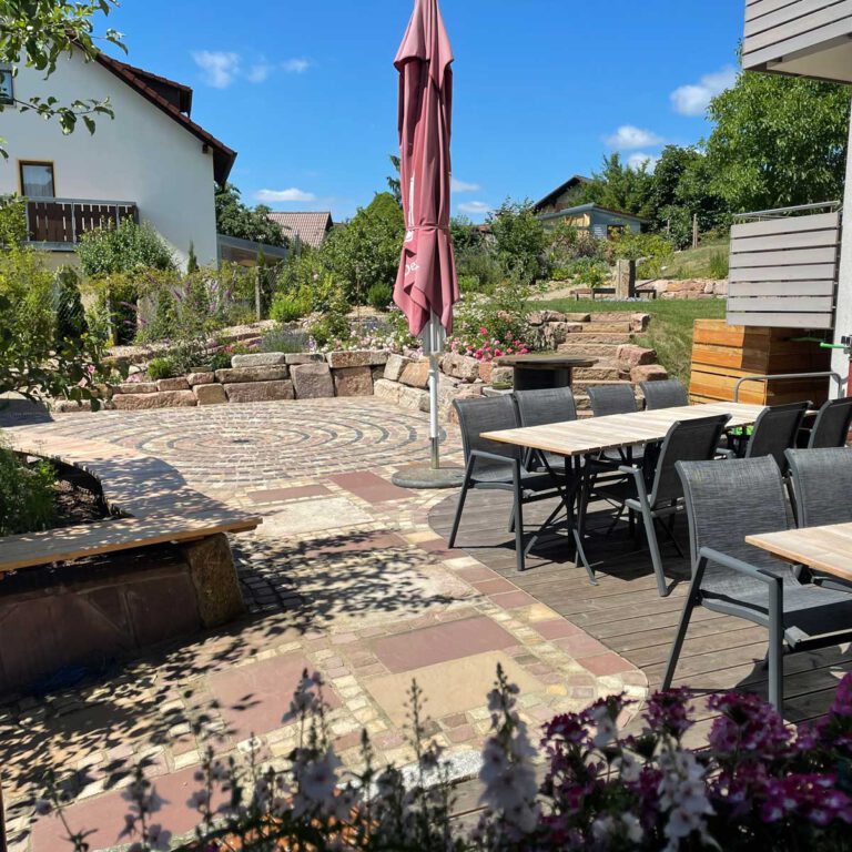 Terrasse und Garten hinter der Pension ist mit einem Mosaik verschönert.